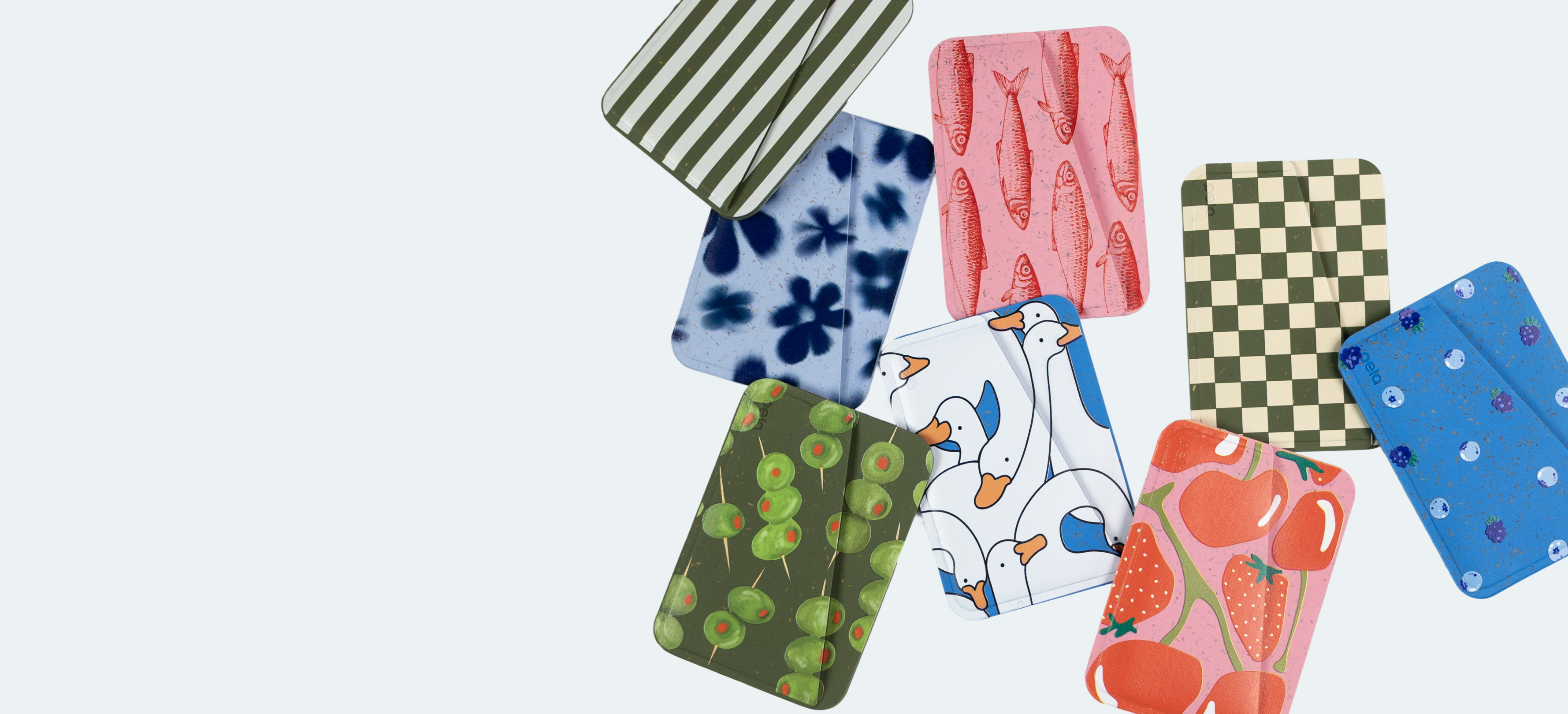 A collection of colorful card holders with various patterns like fish, geese, and fruit against a white background.
