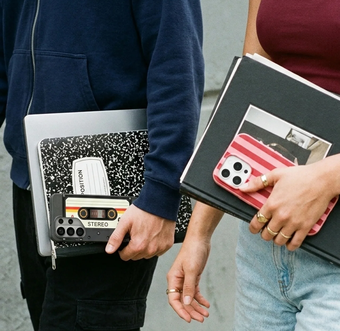 Two people carry books and phones; one phone has a cassette tape case, the other has a striped case.