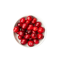 Bowl filled with red cranberries on a white background.