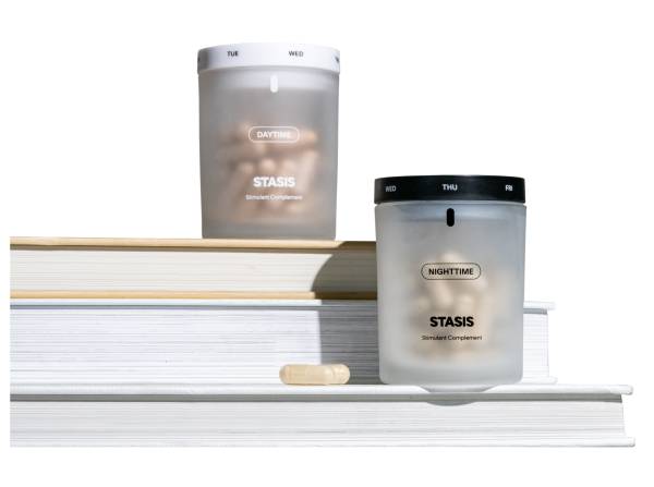 Two containers labeled 'Daytime' and 'Nighttime' on stacked books with a capsule.