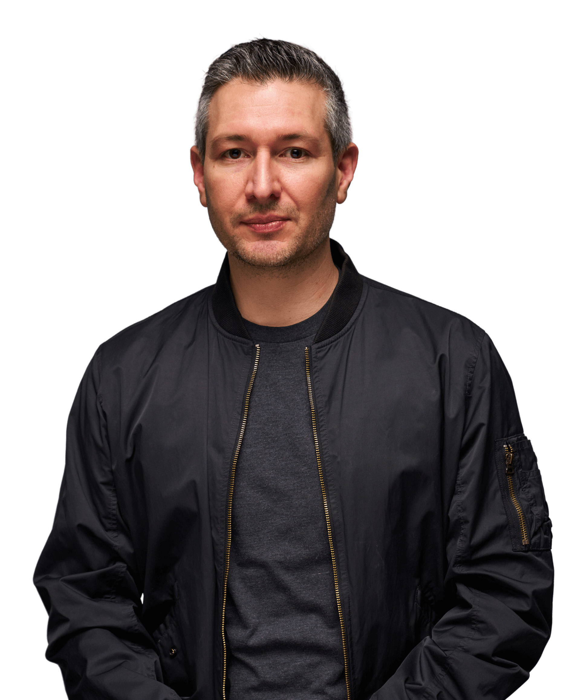 Man in a black jacket with a neutral expression on a green background.