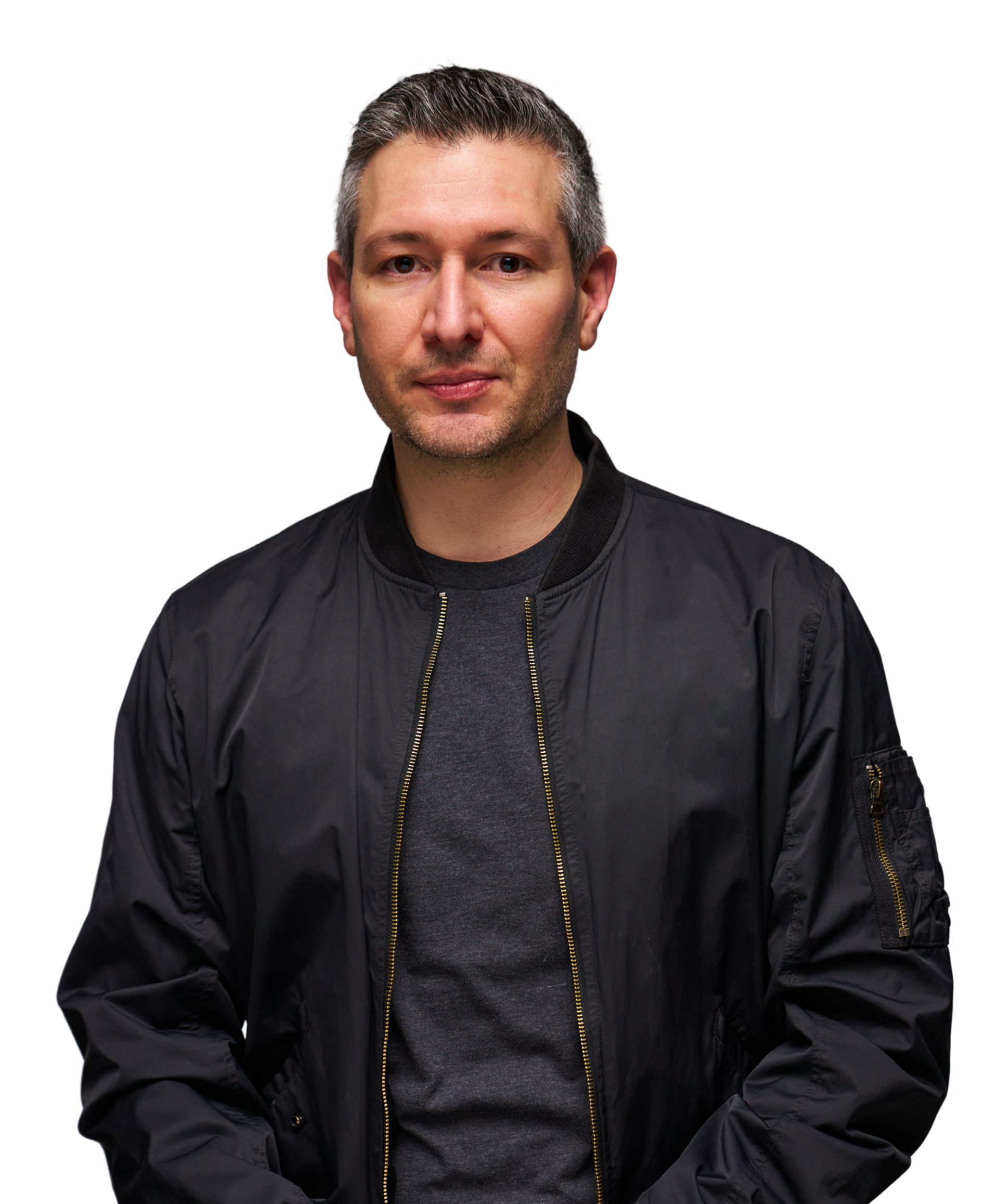 Man in a black jacket and gray shirt against a black background.
