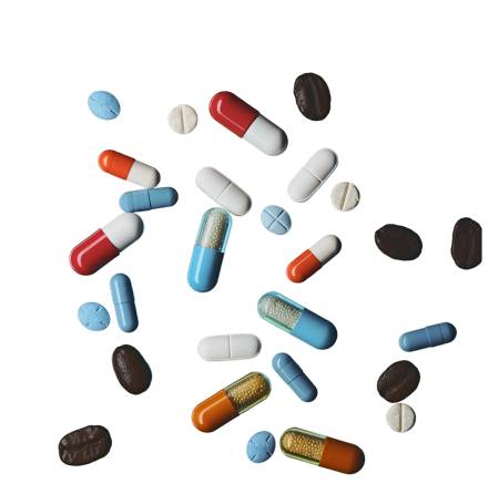 Various colorful pills and capsules scattered on a white background.