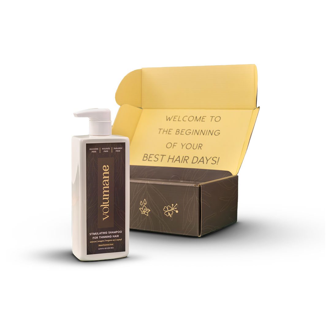 Bottle of Volumane shampoo next to an open box with welcome message.