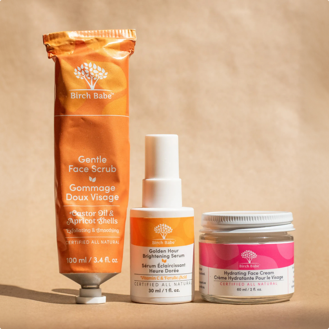 A tube of face scrub, a bottle of serum, and a jar of face cream from Birch Babe.