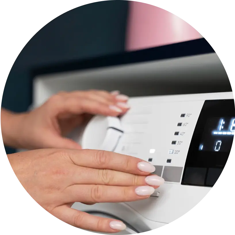 Hands adjusting settings on a washing machine control panel.