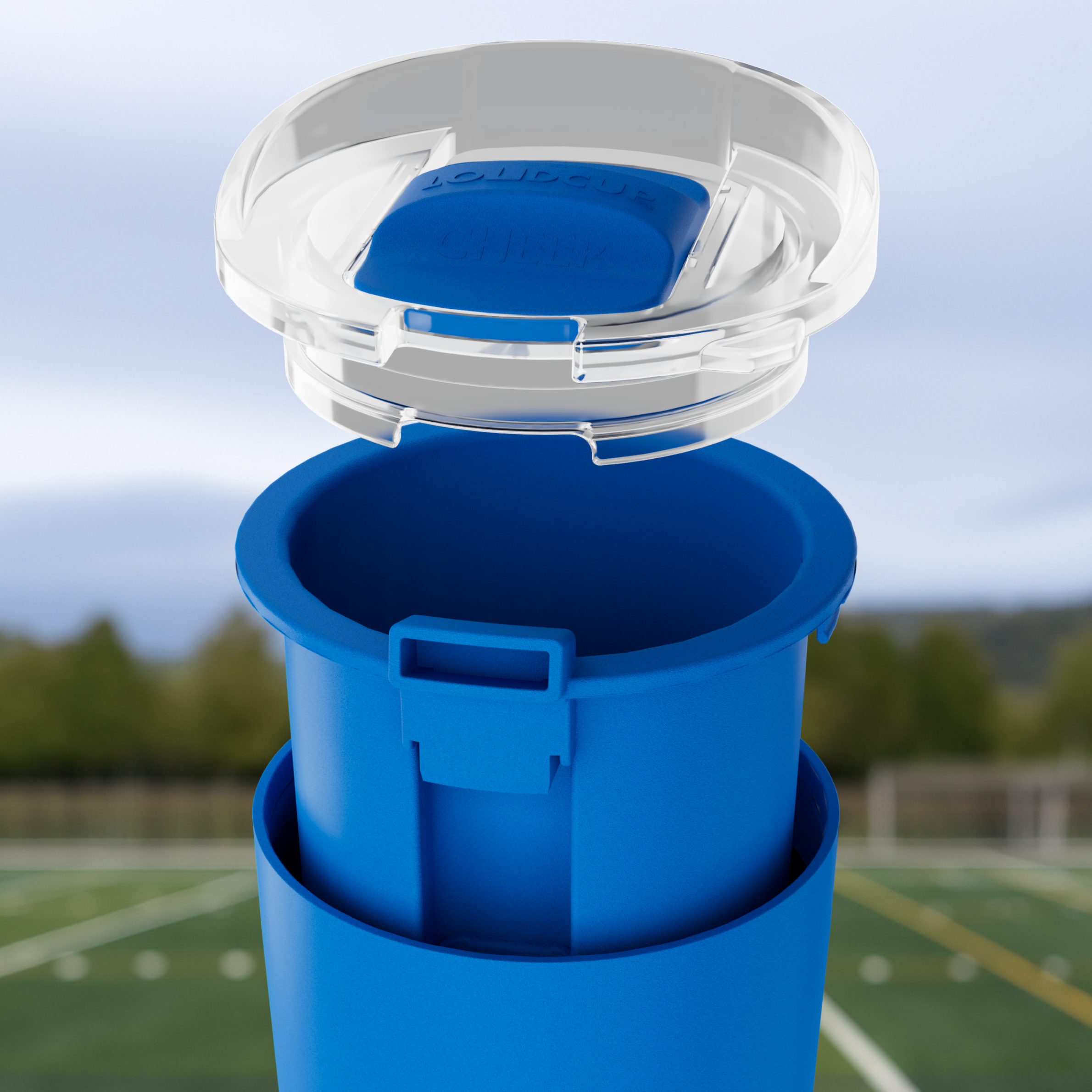 Blue container with a clear lid, outdoors on a sports field.