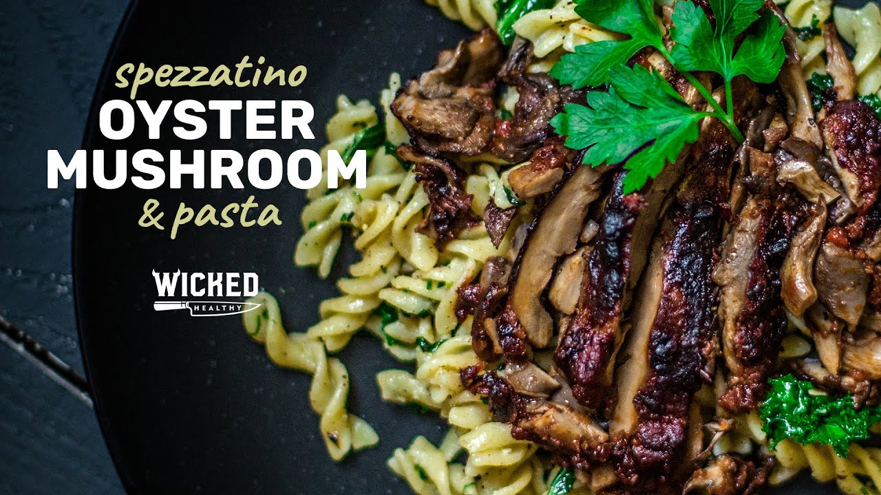 Plate of pasta with oyster mushrooms and garnish, text overlay: 'spezzatino oyster mushroom & pasta'.