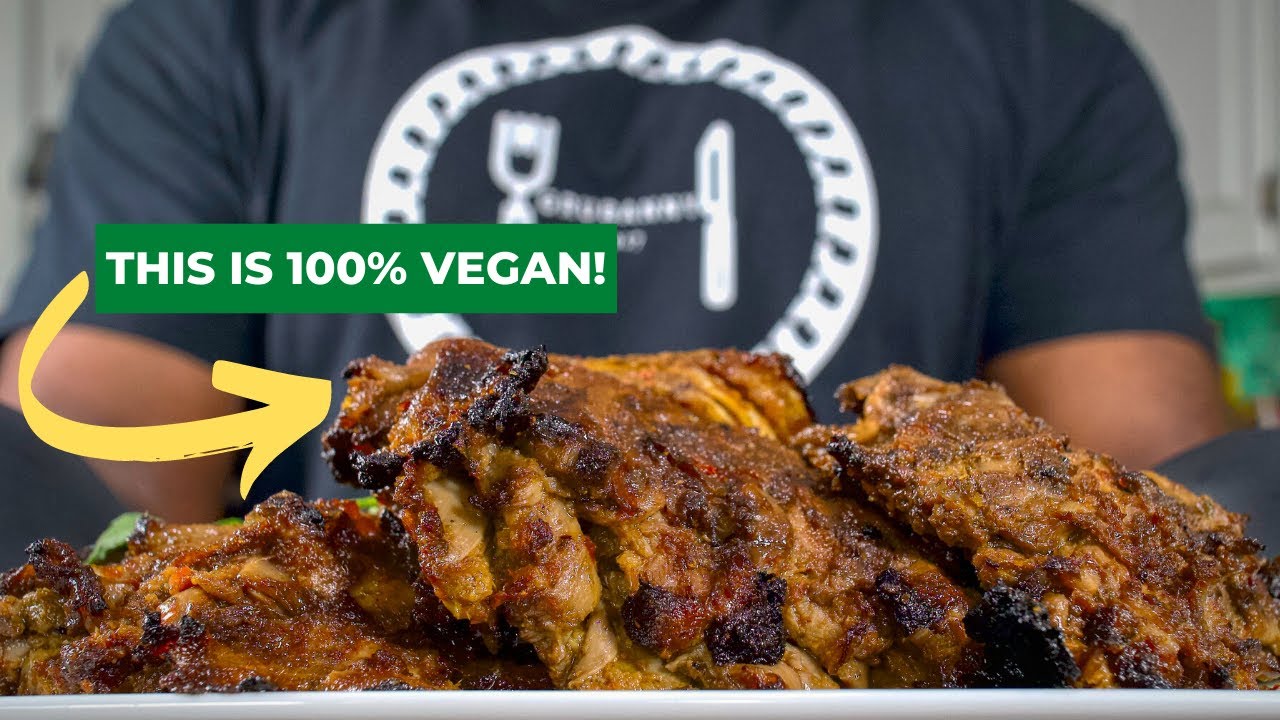 Person wearing a shirt holds vegan meat labeled 'This is 100% vegan!'