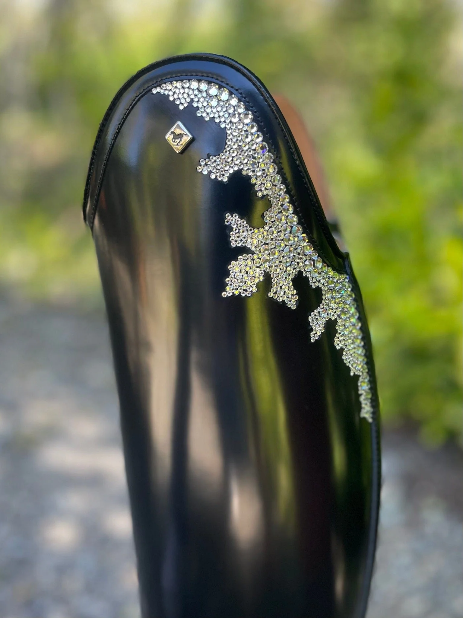 Black leather boot with decorative rhinestones and a small emblem.