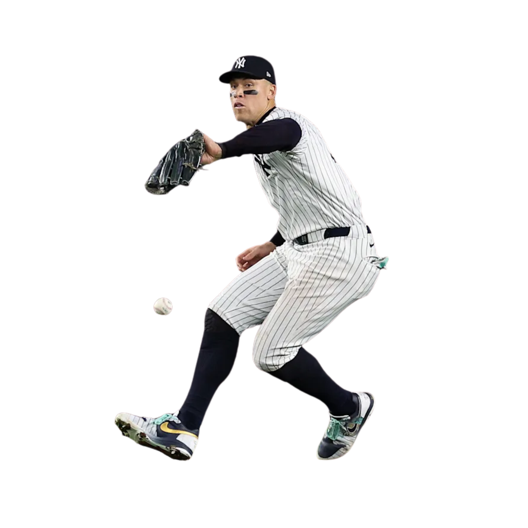 A baseball player in a New York Yankees uniform lunges to field a ground ball.
