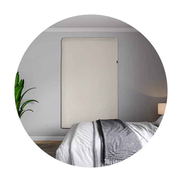 Bedroom with a bed, wall panel, plant, and lamp.