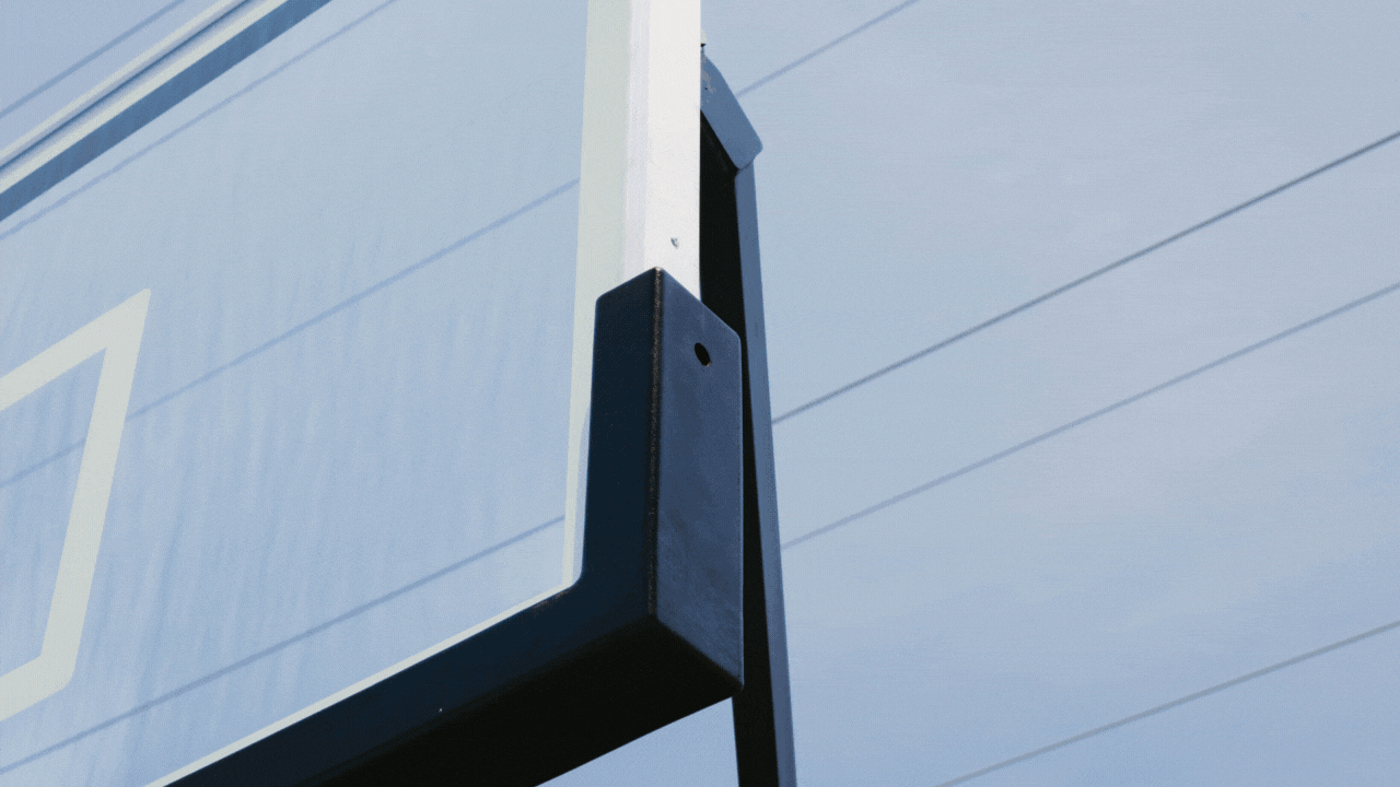 Close-up of a basketball hoop's backboard against a clear sky.