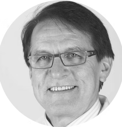 Black and white portrait of a smiling person wearing glasses.