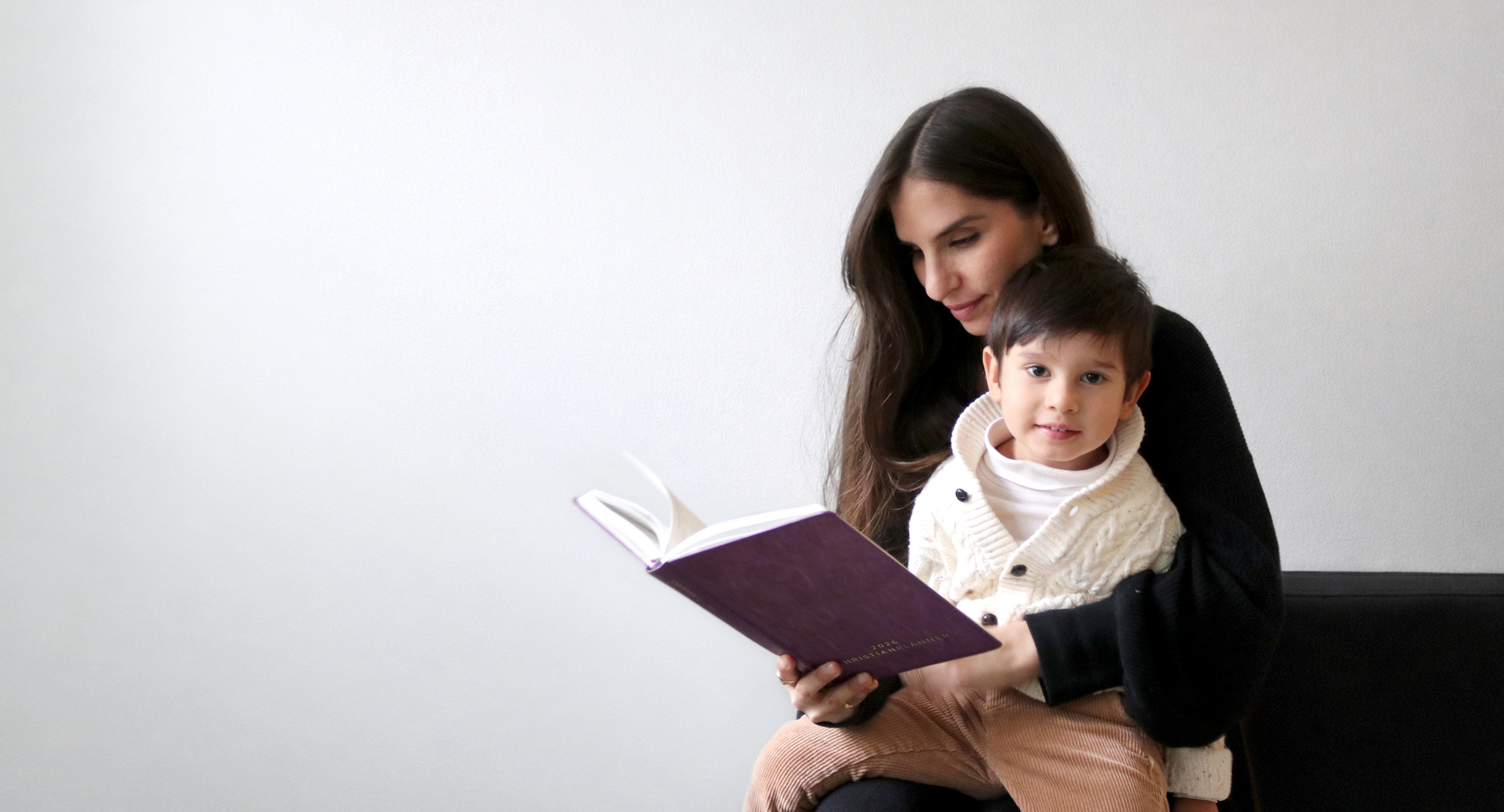 Japanese snack box with tea, snacks, and utensils against a red background.