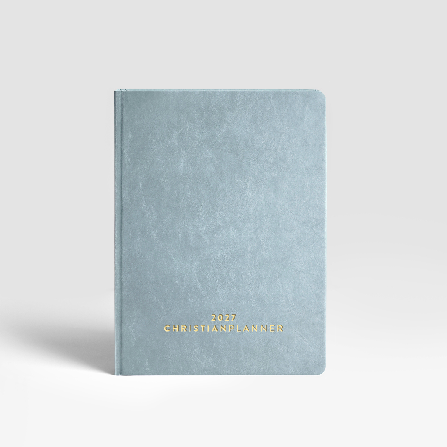 A light blue planner with '2027 CHRISTIAN PLANNER' in gold text on the cover, against a plain background.