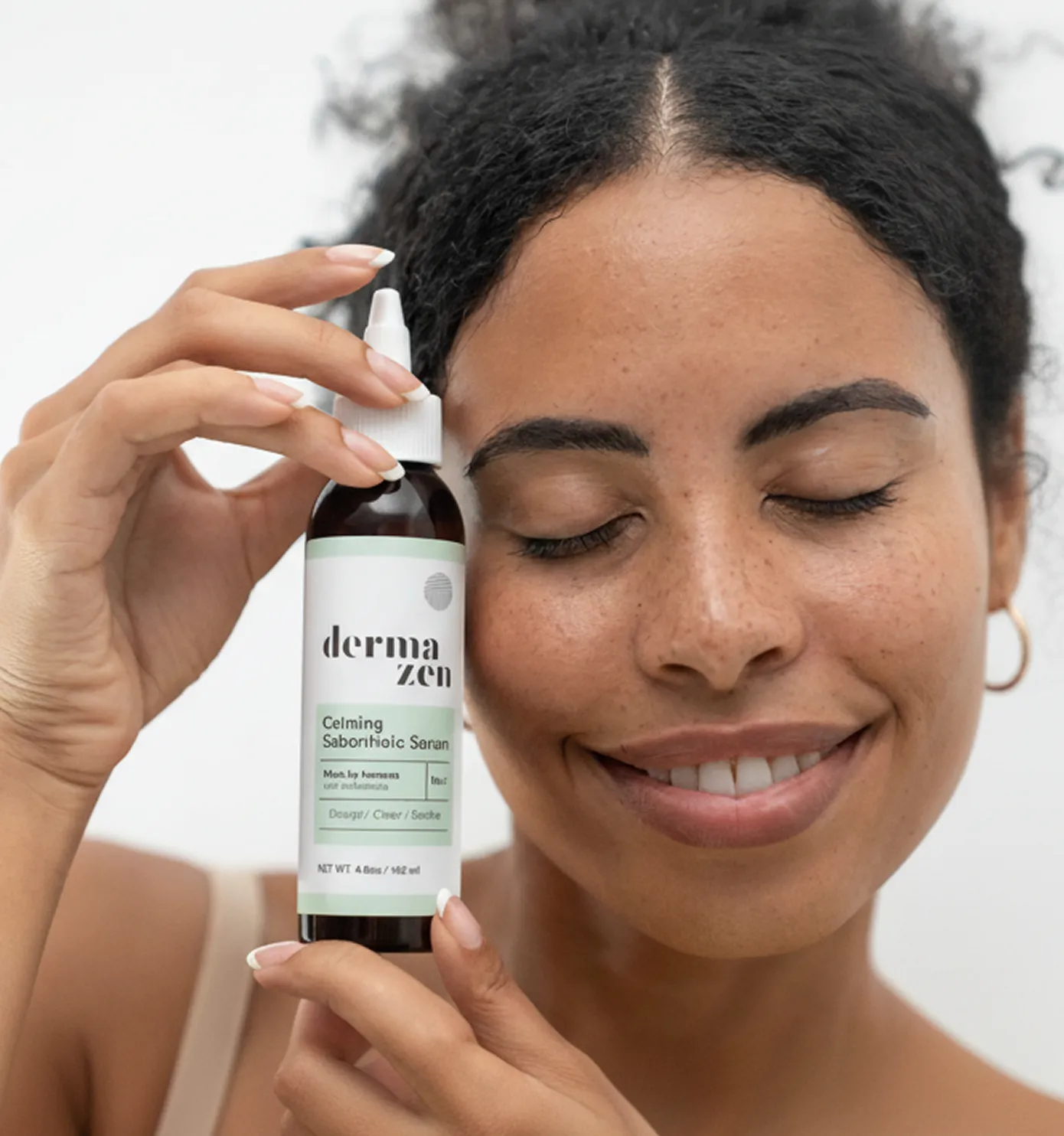A smiling woman with her eyes closed holds a bottle of Dermazen calming serum to her head.