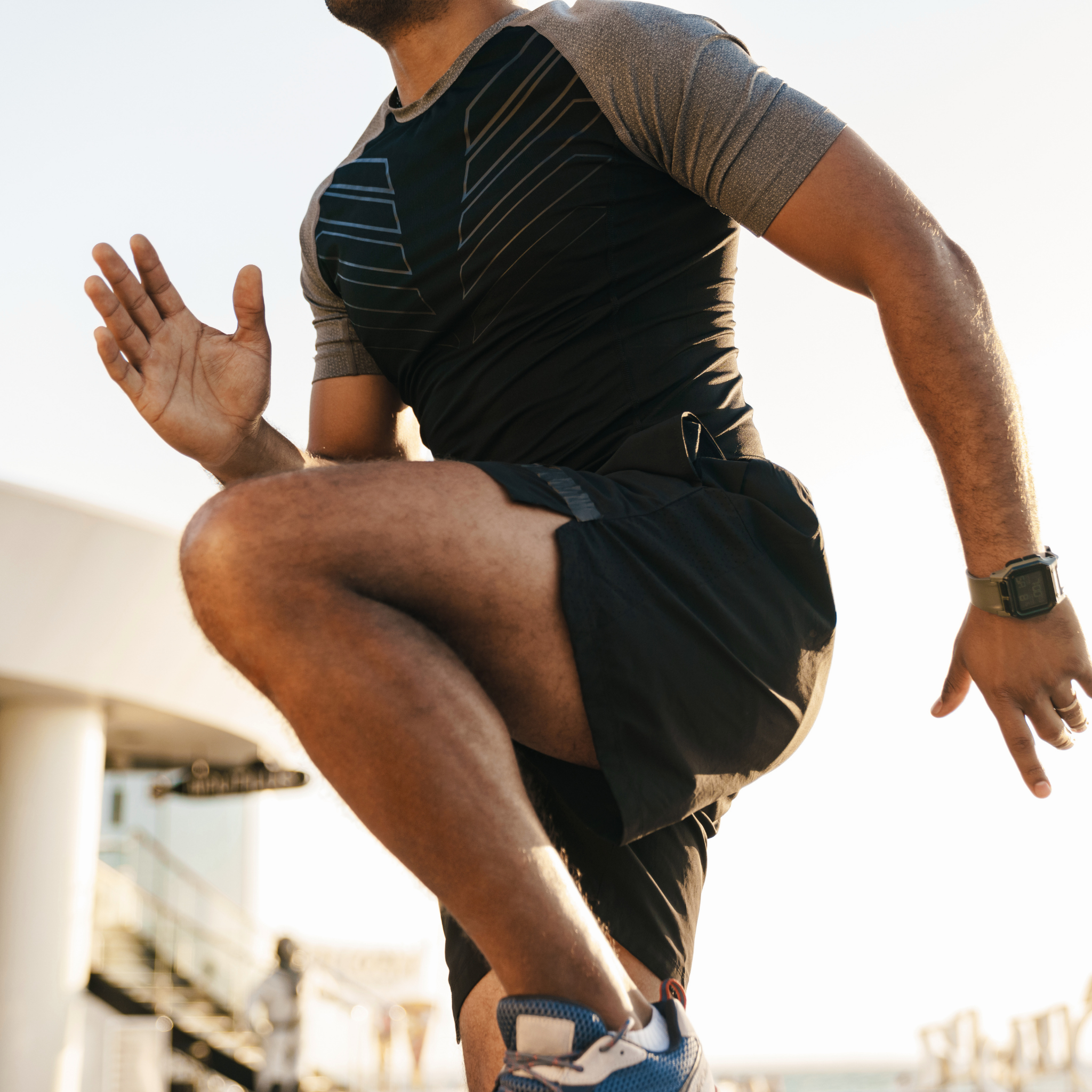 A low-angle, close-up shot of a person in athletic wear exercising outdoors.