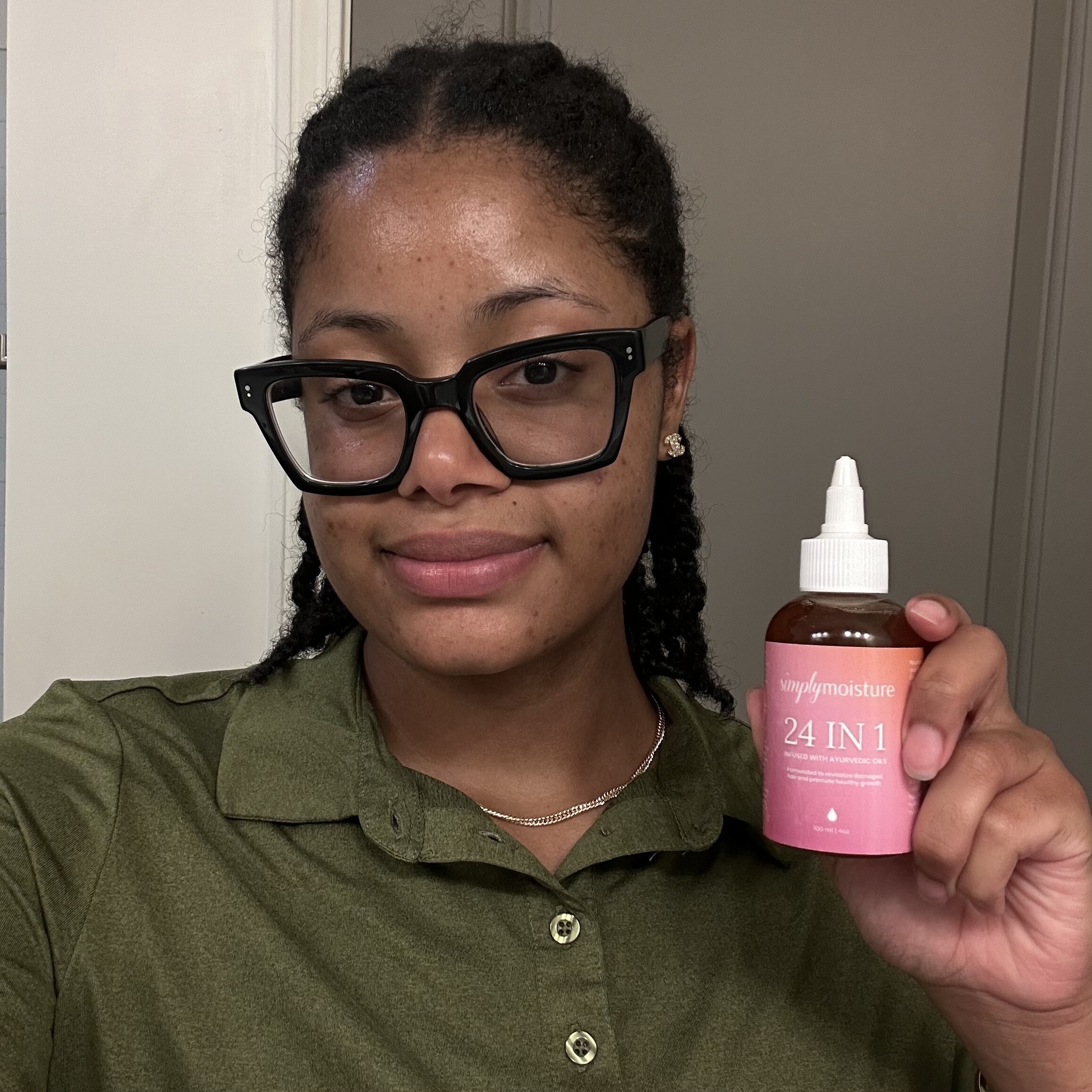 Person holding a bottle labeled 'simply moisture 24 IN 1' with a dropper cap.