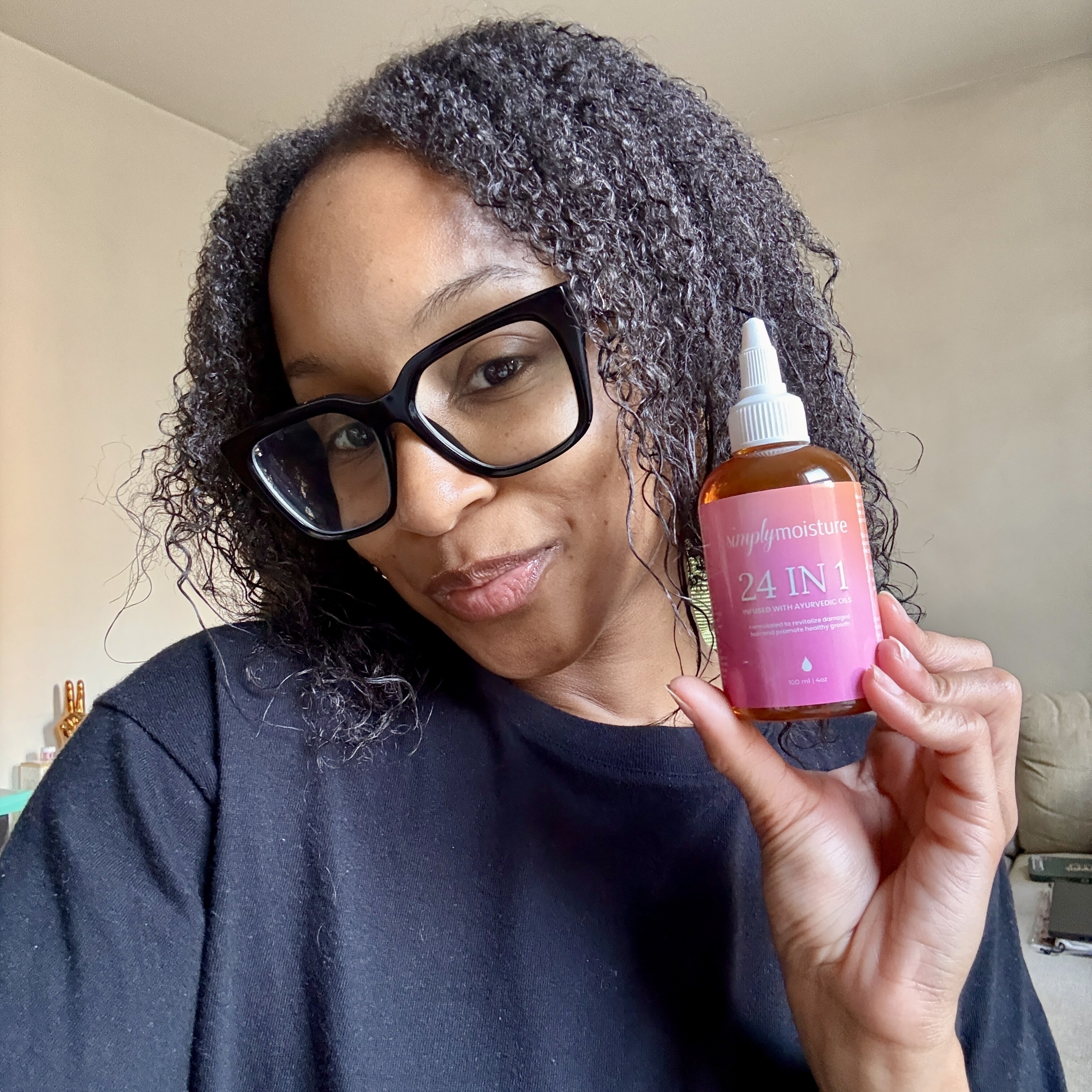 Person holding a bottle labeled '24 IN 1' with a pink label.