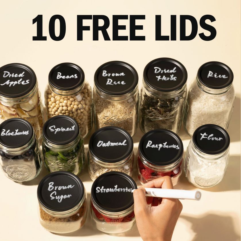 Jars with labeled black lids showing various food items, a hand writing on one lid.