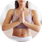 A woman in a yoga pose with her hands pressed together in front of her chest.