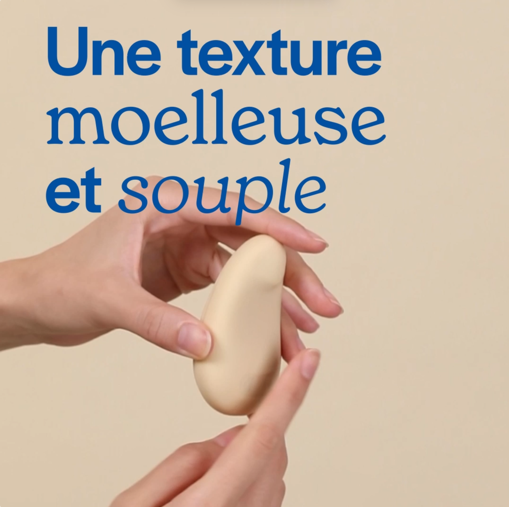 Hands holding a soft, beige object with French text above.
