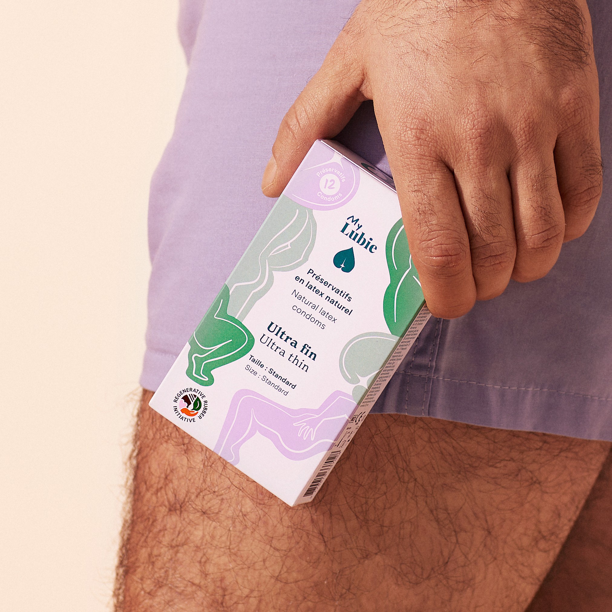 Person holding a box of ultra-thin natural latex condoms.