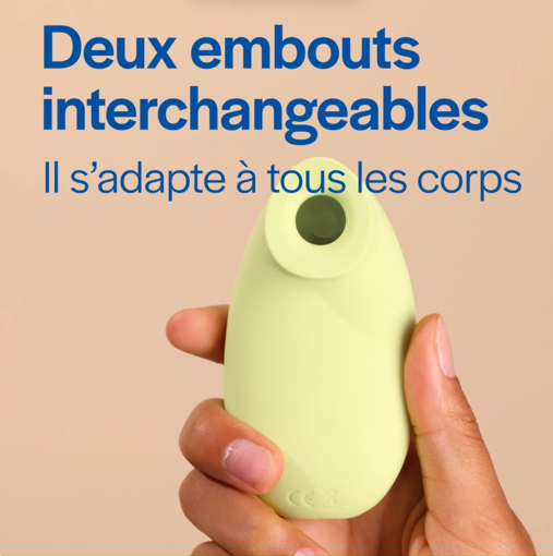 Hand holding a small, light green device with French text above.