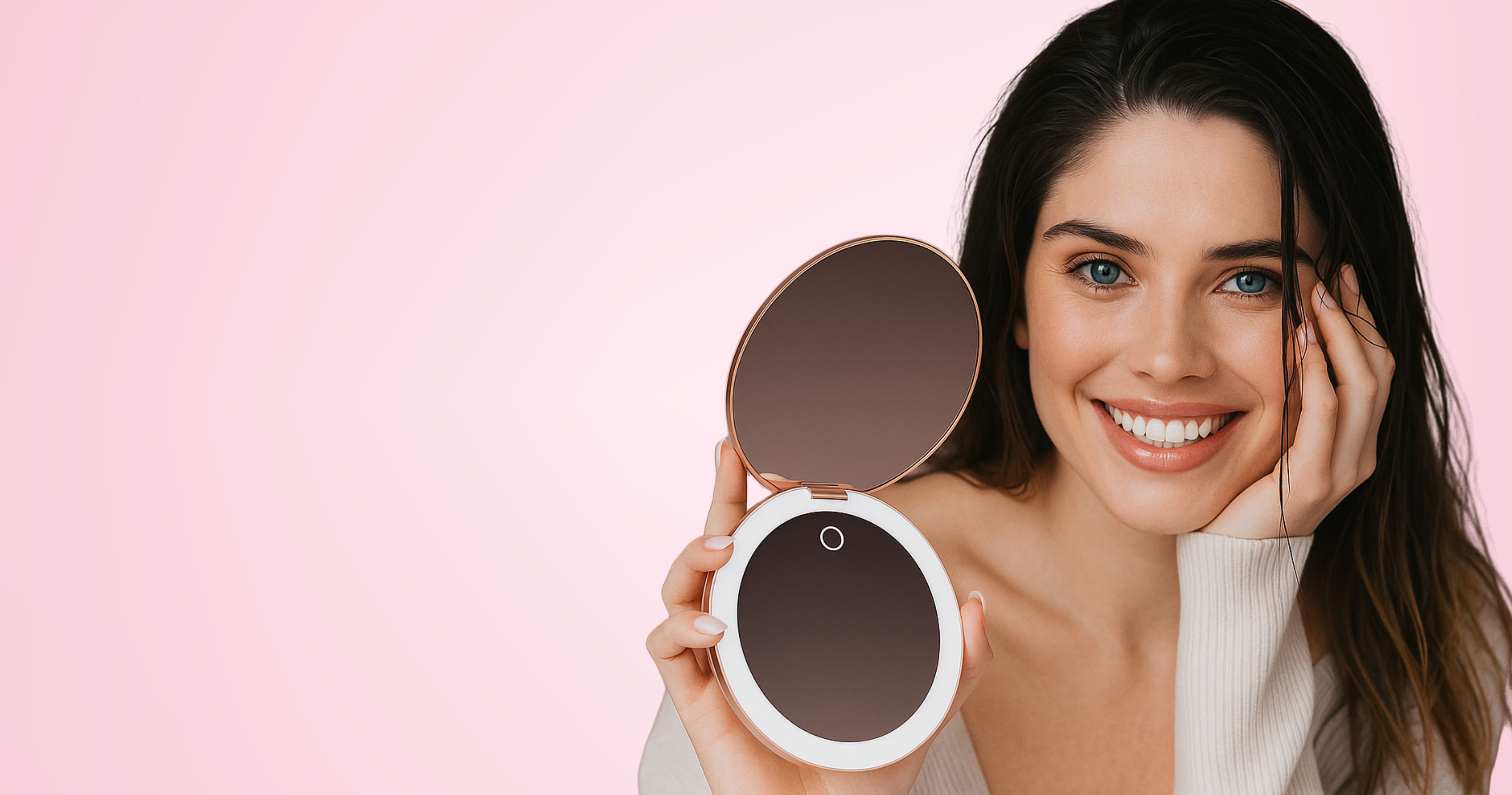 Smiling person holding a round mirror against a pink background.