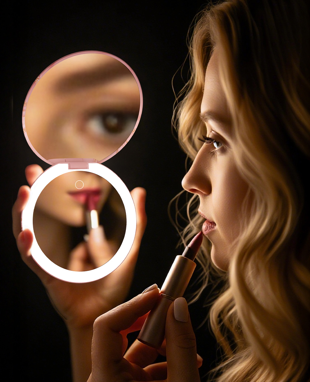 Woman applying lipstick, reflected in a circular mirror with light.