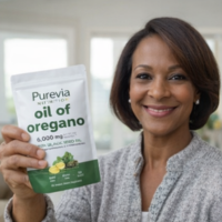 A smiling woman holds up a pouch of Purevia Nutrition oil of oregano supplements.