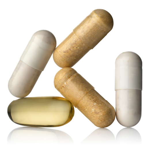 A close-up of several assorted supplement capsules and one yellow softgel on a reflective white surface.