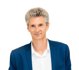 Man in a blue suit and white shirt, smiling.