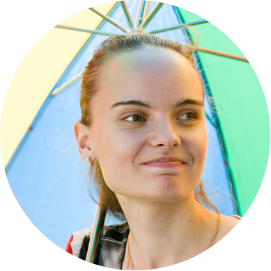 Person holding a colorful umbrella, smiling slightly.