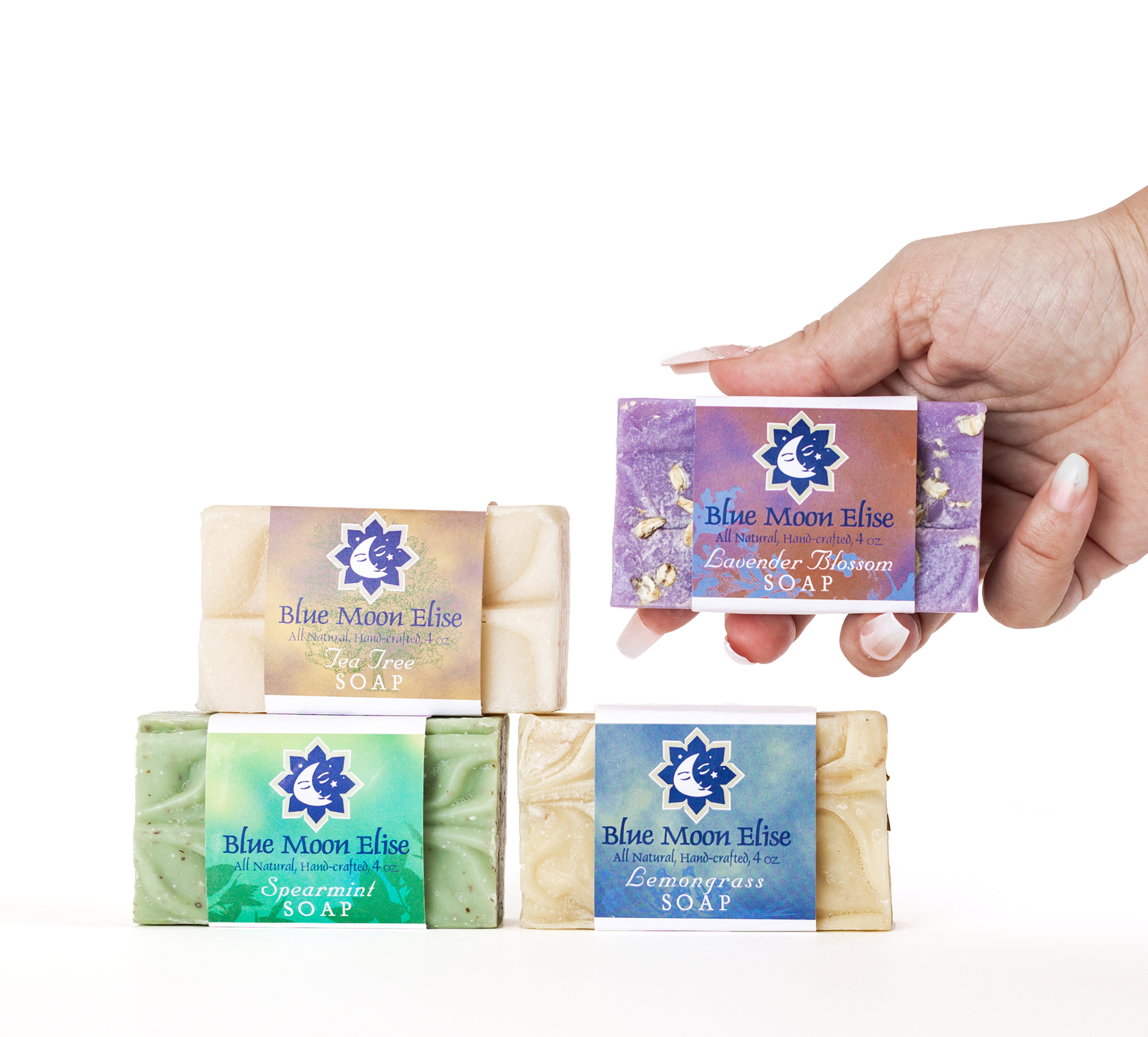Four bars of Blue Moon Elise soap, one held in a hand.
