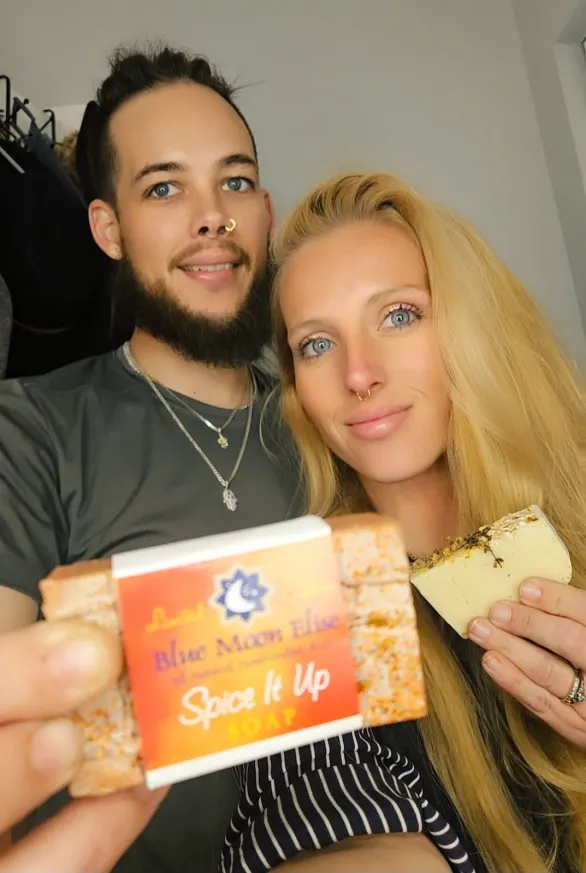 Two people holding bars of soap, smiling at the camera.