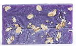 Purple soap bar with oats embedded on the surface.