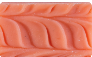 Close-up of a textured, orange soap bar with wavy patterns.