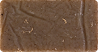 Close-up of a brown textured surface with small specks and lines.
