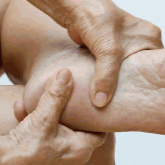 Hands massaging a person's heel and ankle.