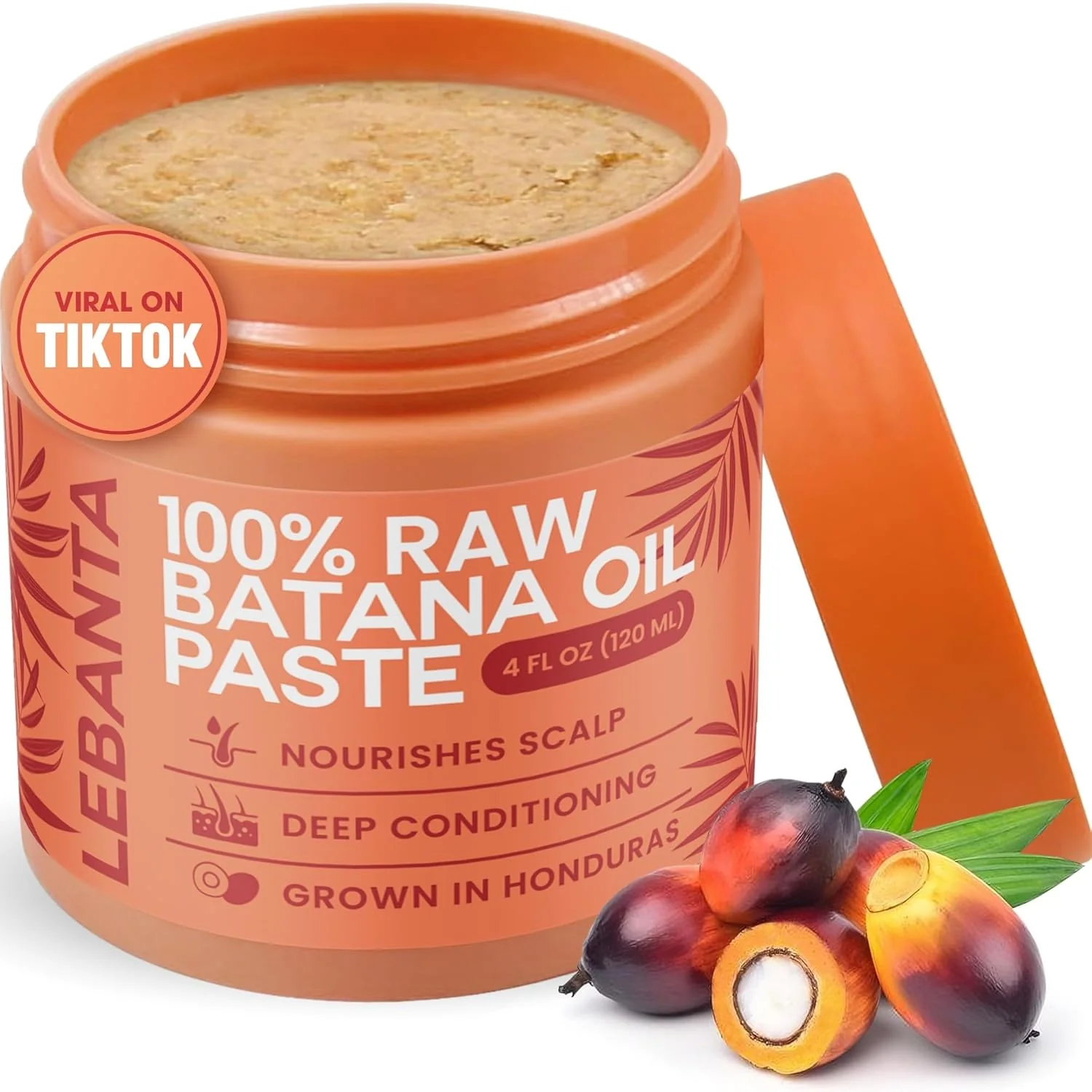 An open orange jar of Lebanta 100% Raw Batana Oil Paste with several palm fruits in front.