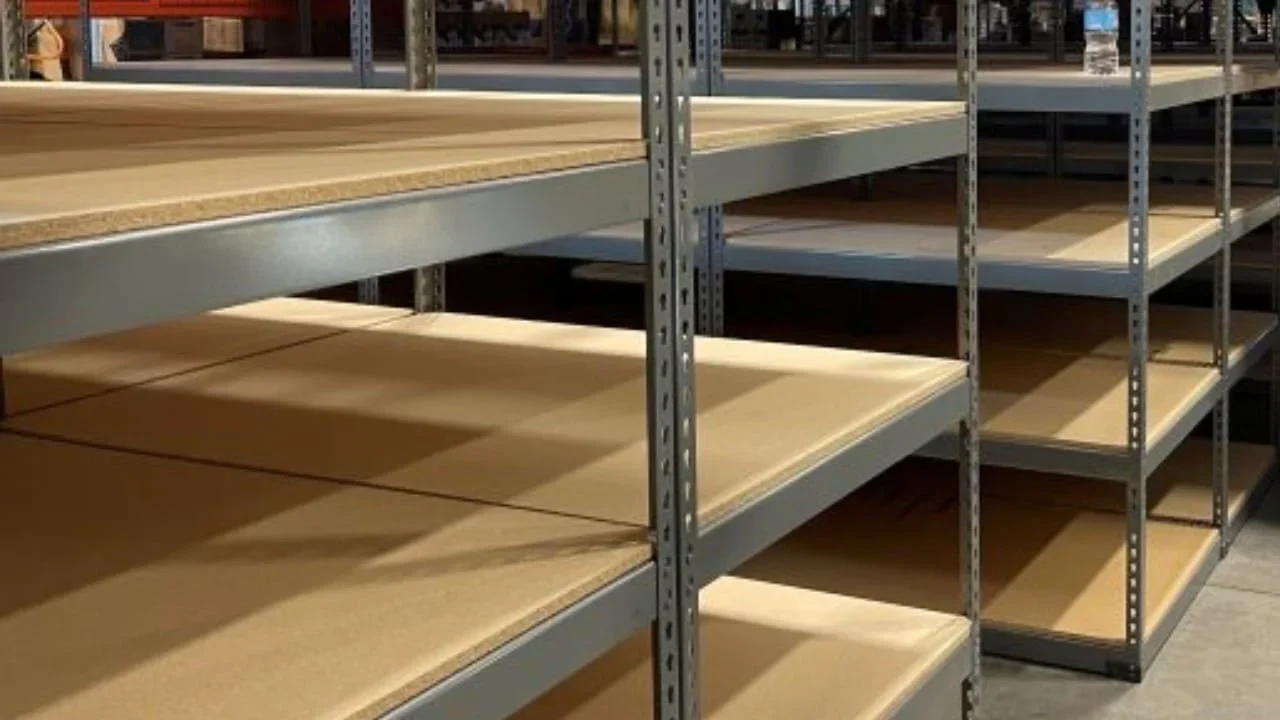Empty metal shelves in a warehouse setting.