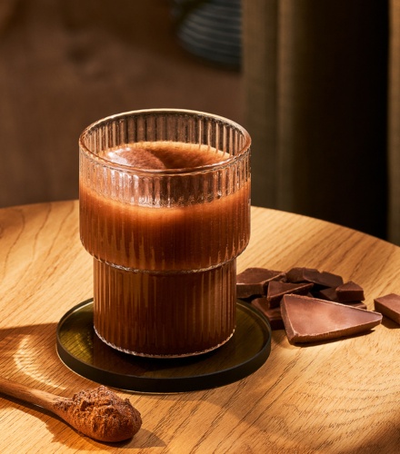 cup with hot cocoa inside on a table with chocolate next to it