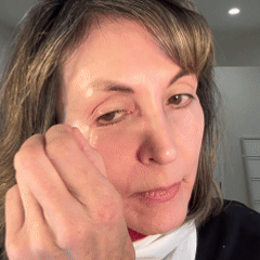 Person applying a skincare product under the eye.