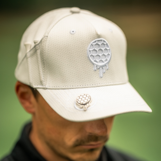 Person wearing a light beige cap with circular textured design.