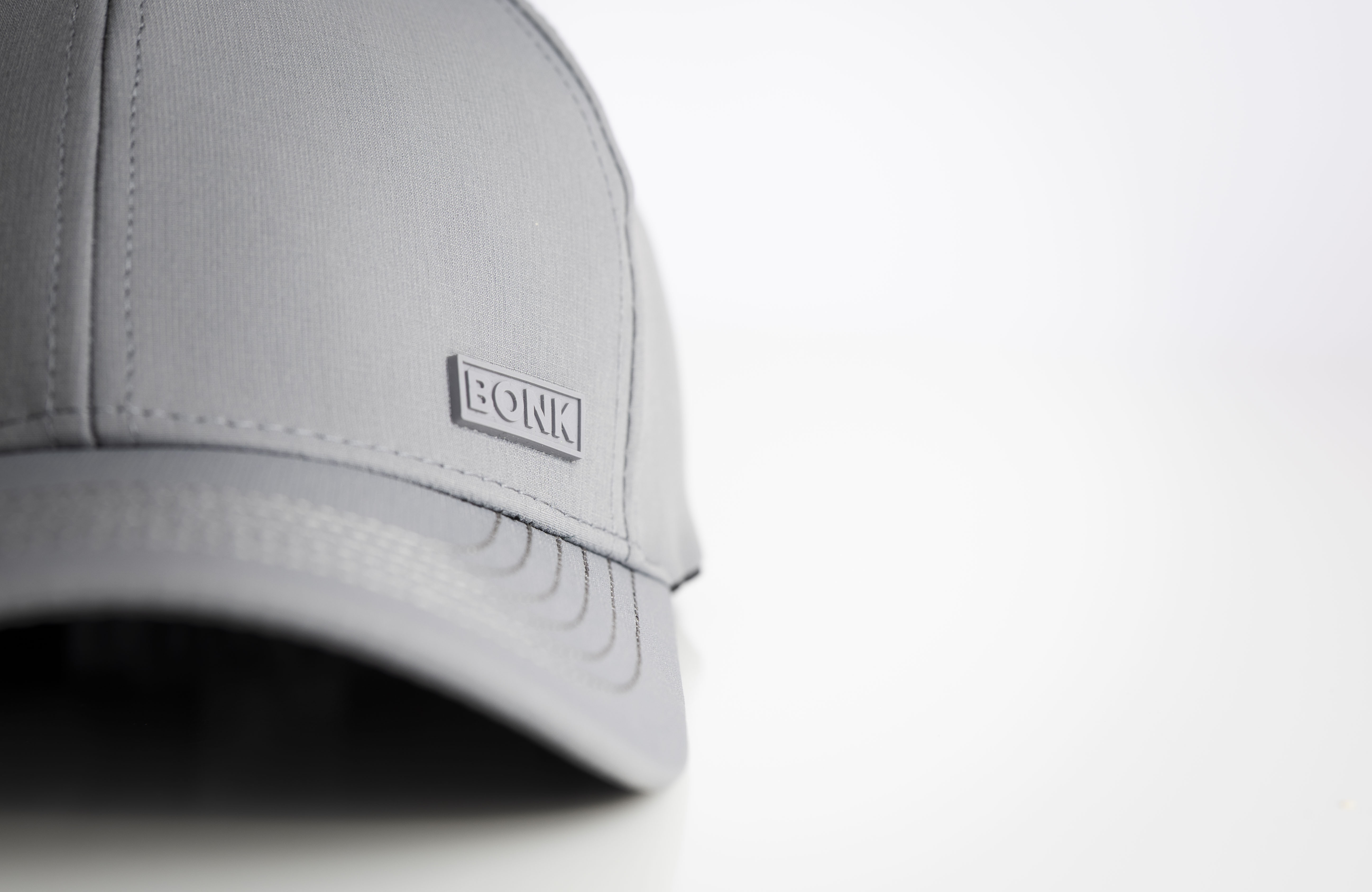 A close-up shot of a grey baseball cap with a 'BONK' logo against a white background.