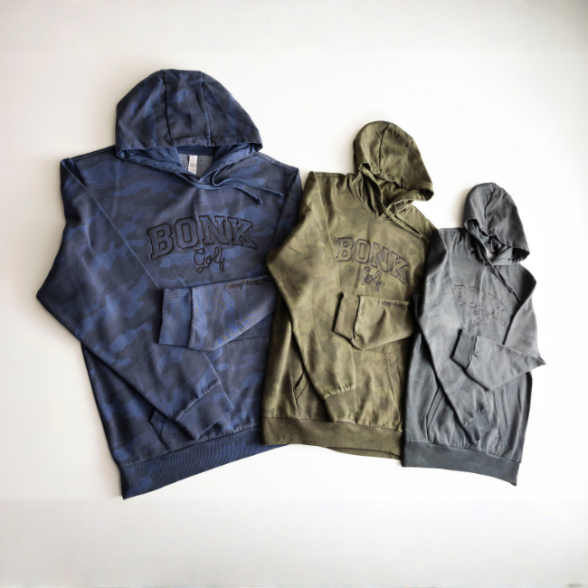 Three 'BONK Golf' hoodies in blue camo, olive, and gray, laid flat on a white background.