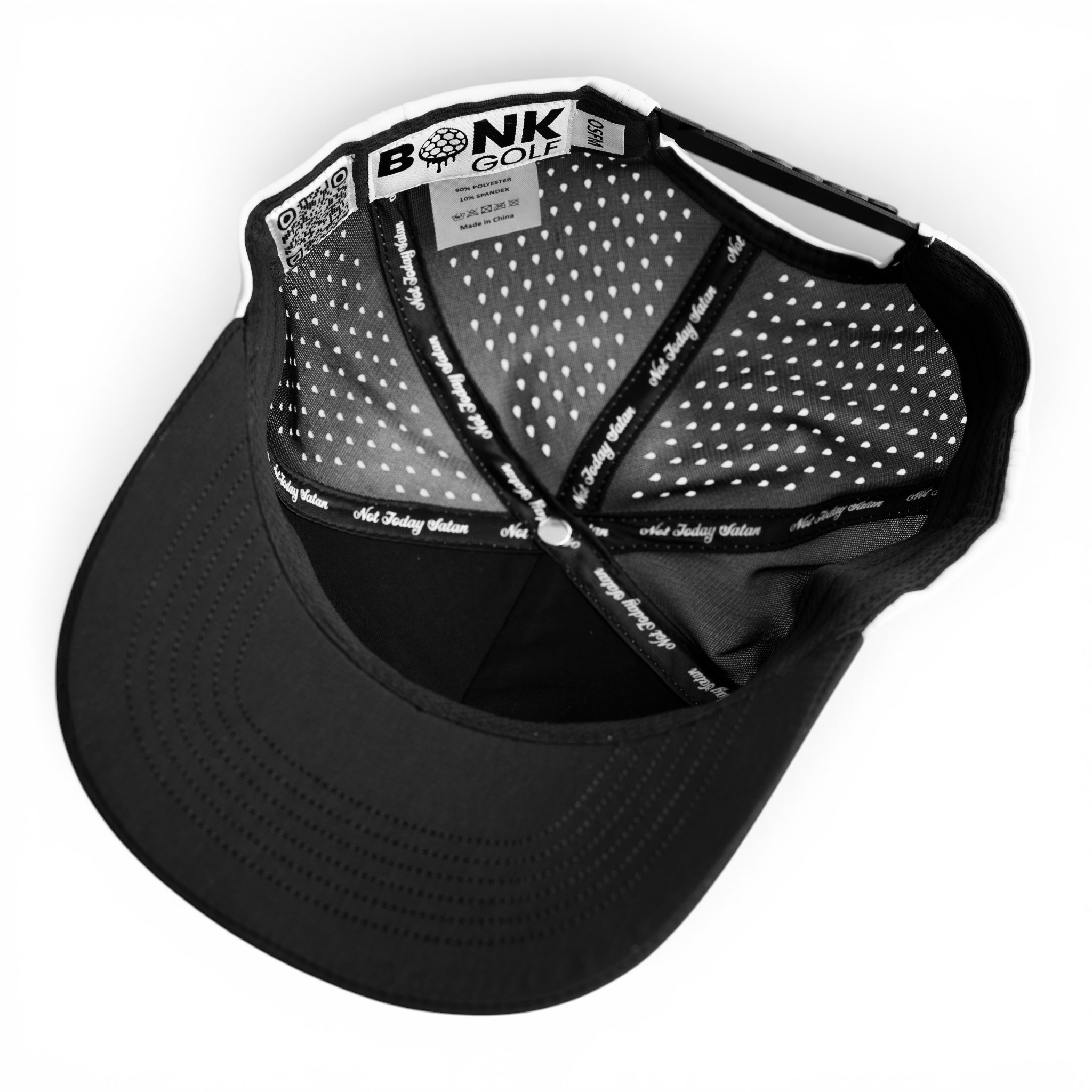 The inside of a black and white BONK GOLF cap showing its perforated lining and branded tags.