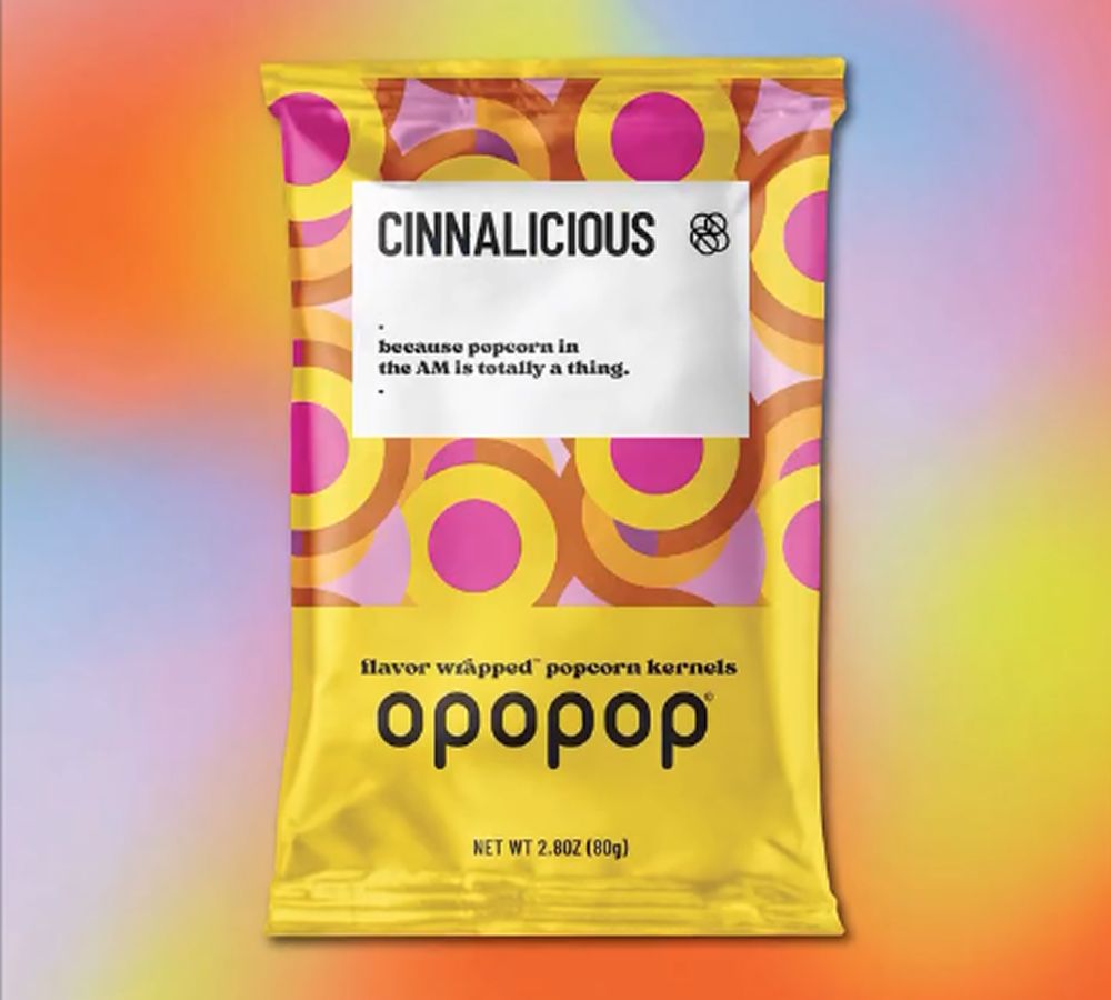 Colorful popcorn packaging with 'Cinnalicious' and 'opopop' branding on a gradient background.